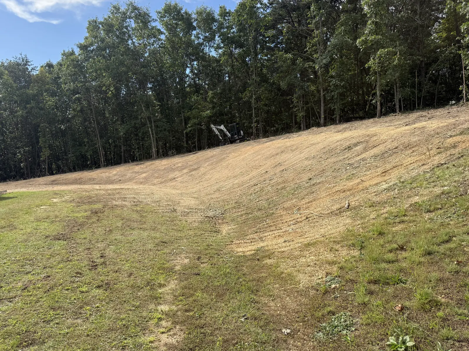 Bank graded smooth after the trees and brush were cleared off it