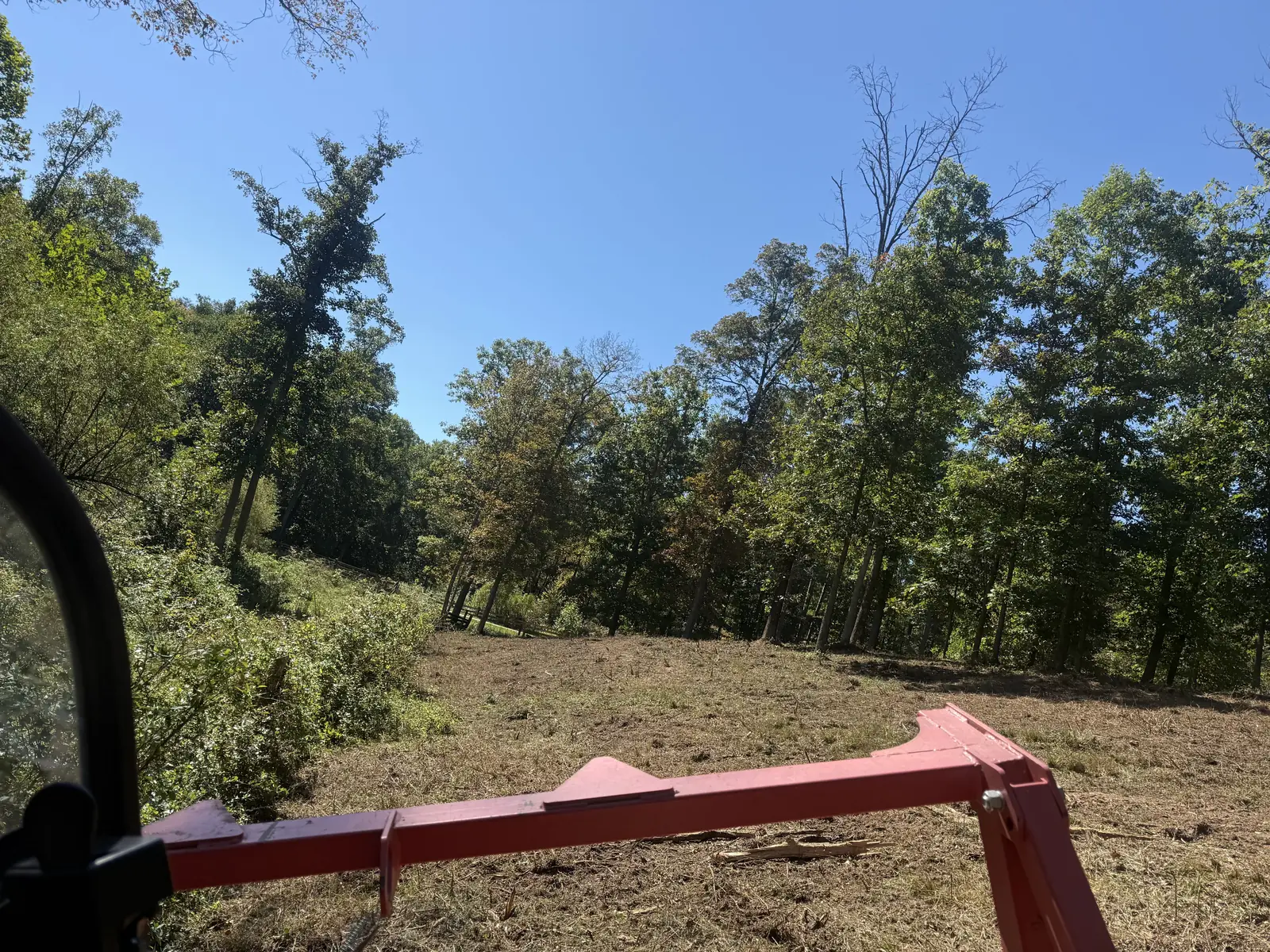 Mulched ground seen from the loader cab over the mulcher's push bar